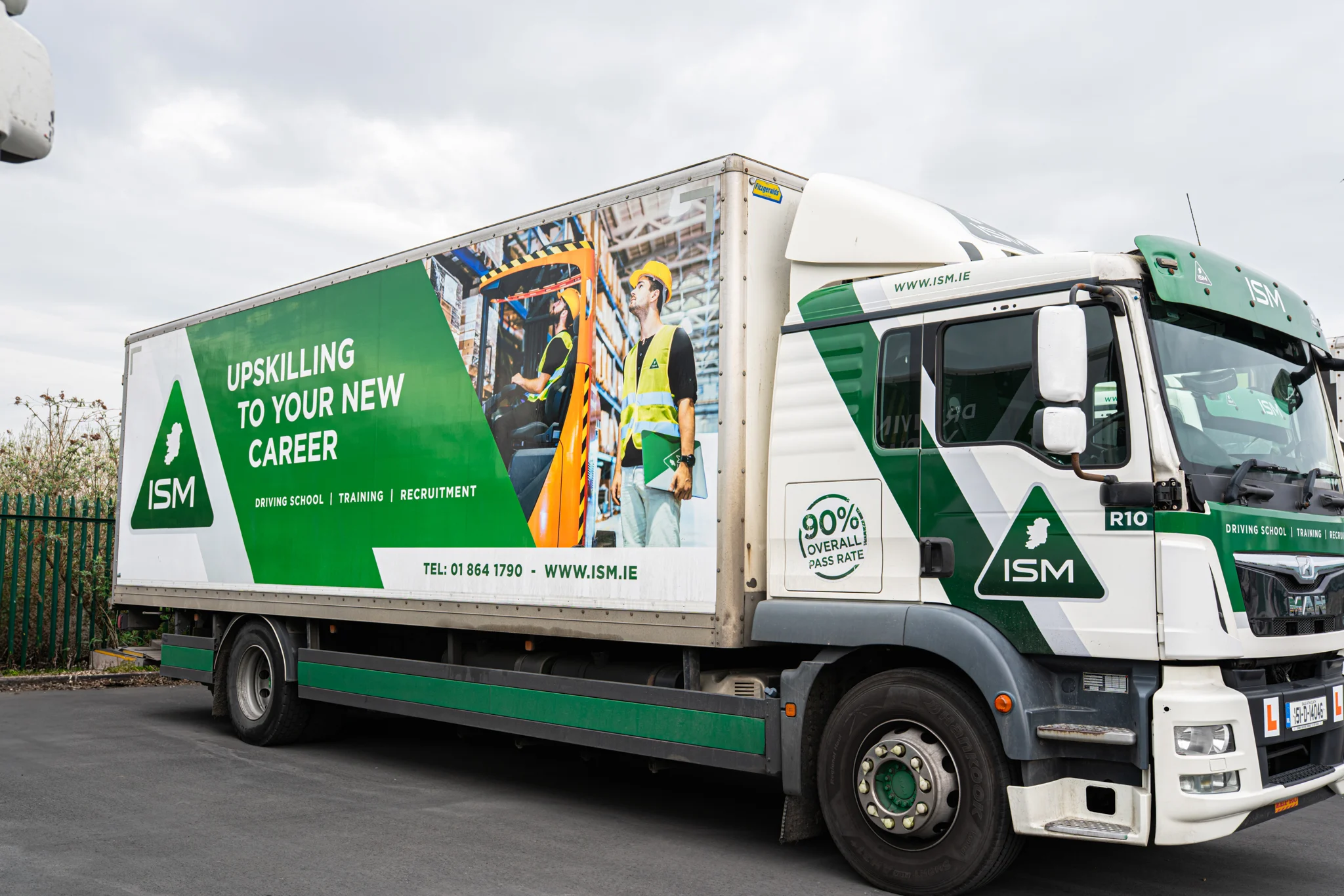 A_truck_displaying_a_ISM_logo_parked_on_a_street_ISM_Driving_lessons