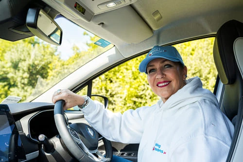 A_woman_driving_instructor_sitting_on_a_car_ISM_Driving_lessons