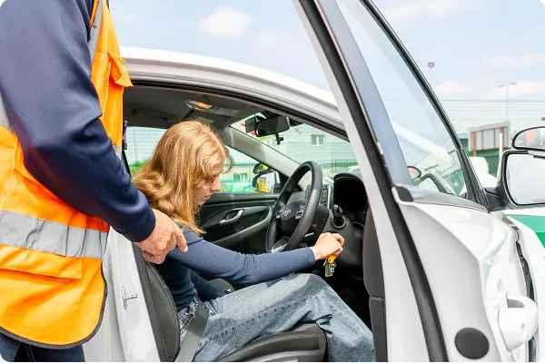 A_woman_is_seated_in_the_driver's_seat_of_a_car_preparing_to_drive_ISM_Driving_lessons