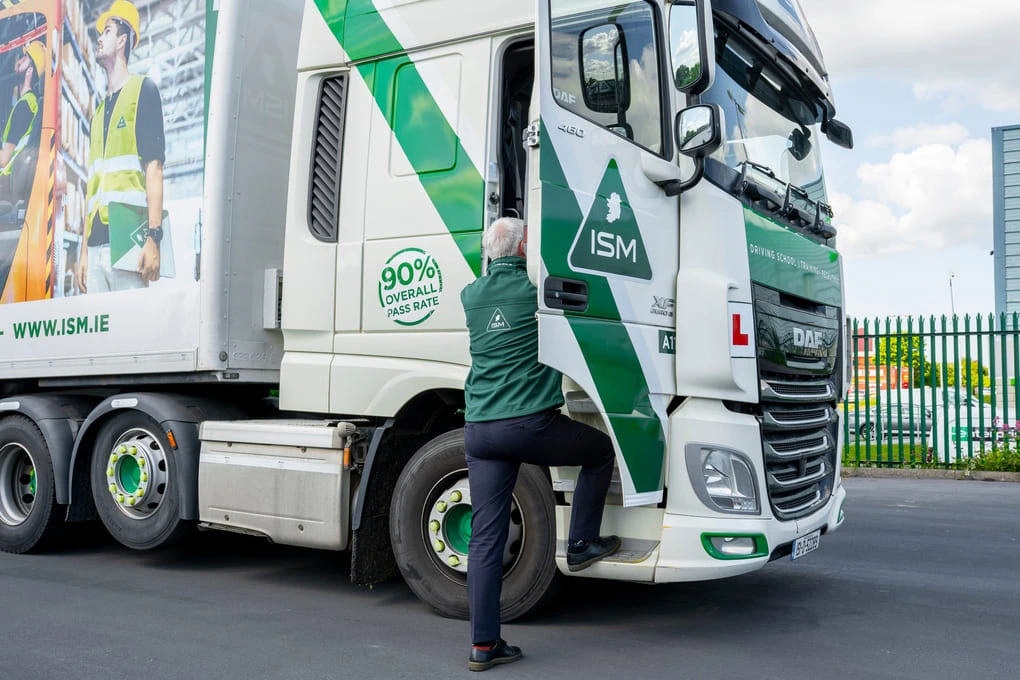 A_man_is_climbing_large_ISM_truck_ISM_Driving_Lessons