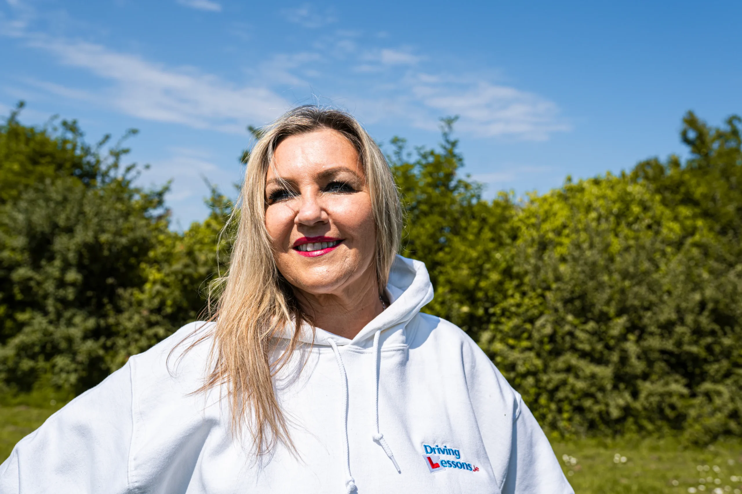 Woman_driving_intructor_standing_ISM_Driving_lessons