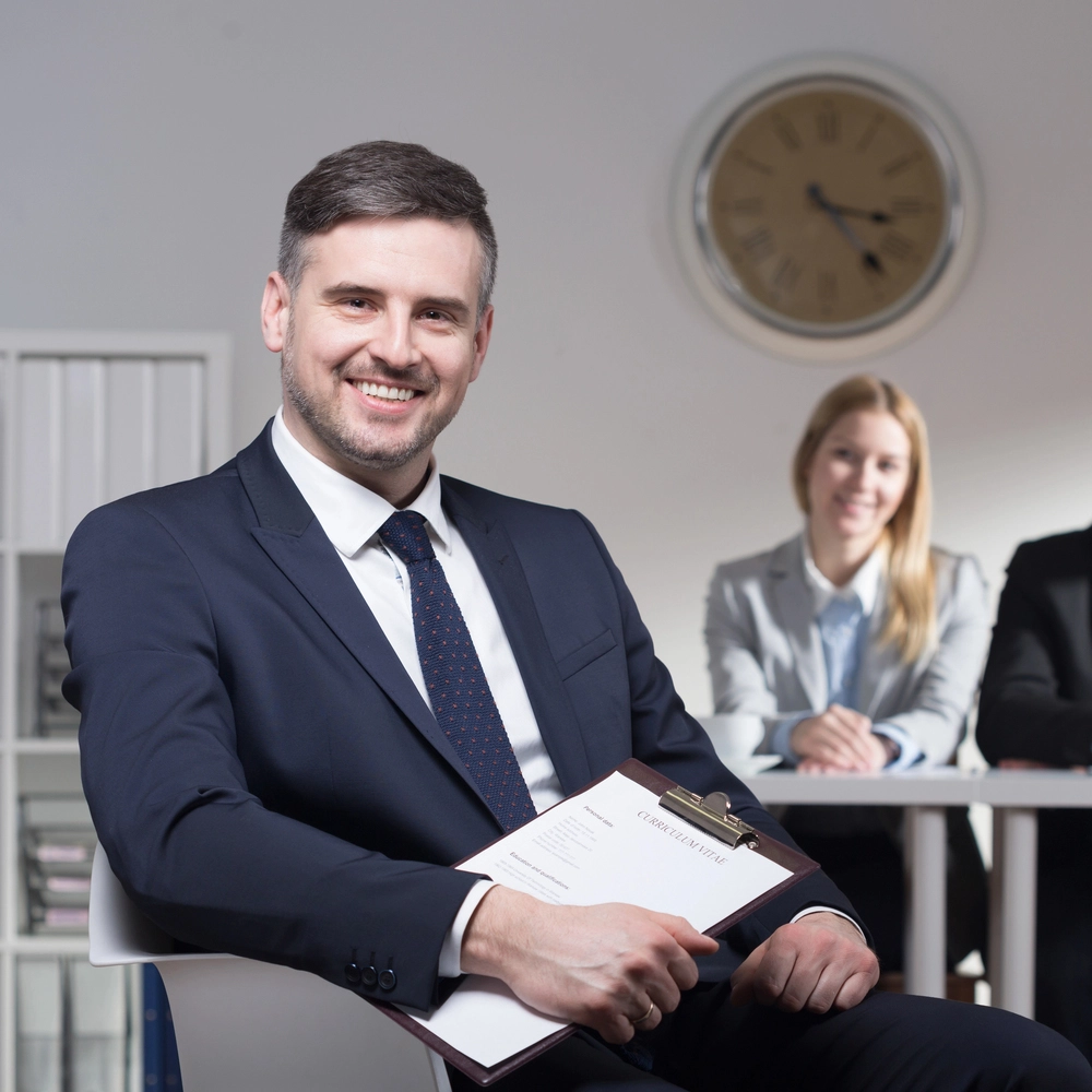 A_man_in_a_suit_holds_a_clipboard _ISM Training_and_Recruitment