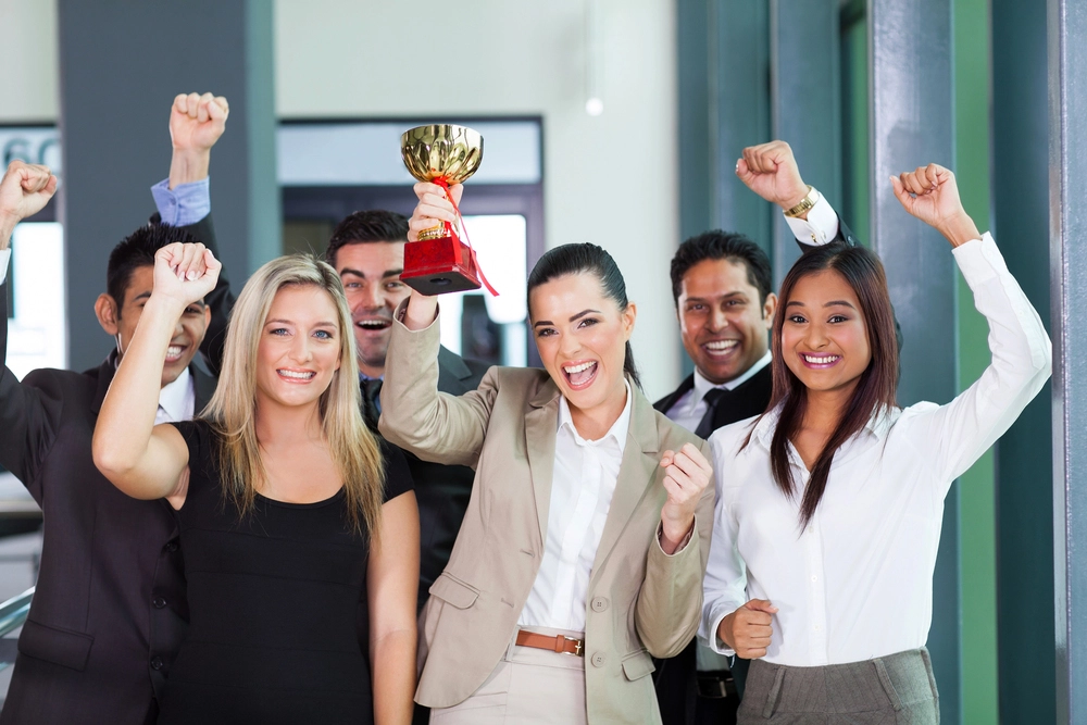 Business_team_joyfully_celebrating_with_a_trophy _ISM Training_and_Recruitment