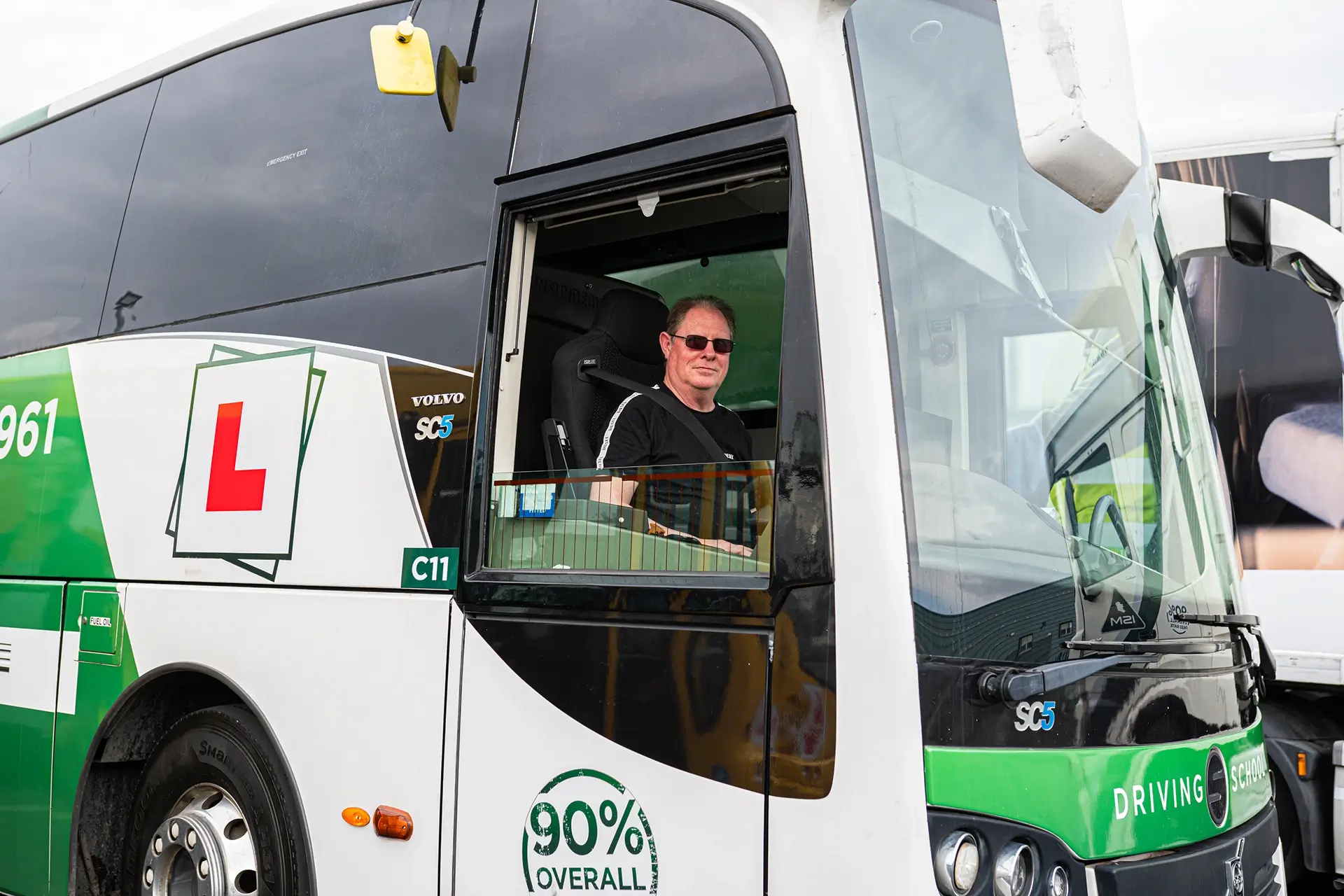 Driving_instrcutor_seated_in_the_driver's_seat_of_a_volvo_bus_ISM_Driving_lessons
