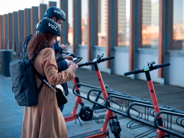 A_woman_and_a_man_stand_beside_a_scooter_ISM_Driving_Lessons