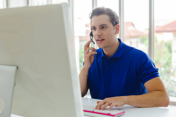 A_man_talking_on_the_phone_while_sitting_at_a_desk _ISM_Training_and_Recruitment